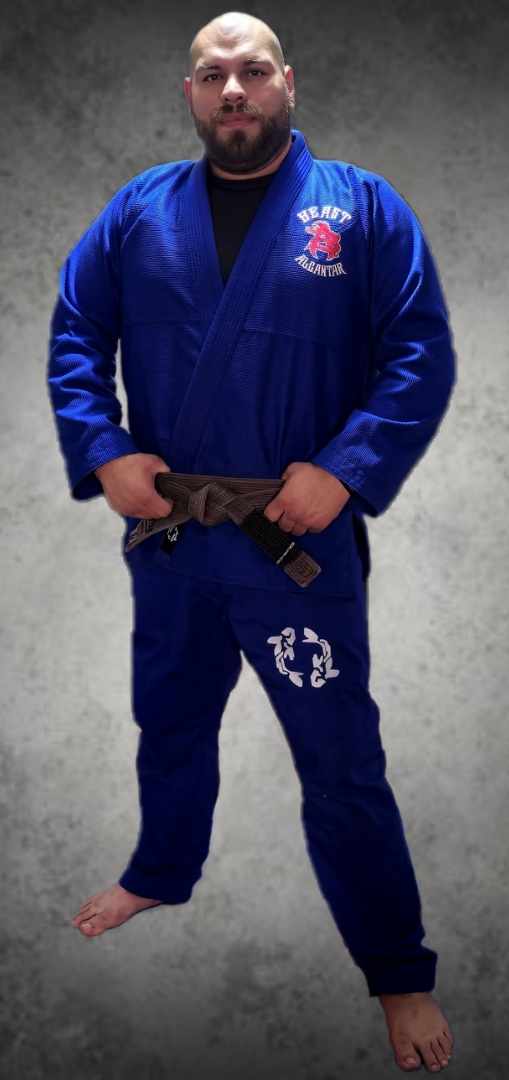 A man in blue uniform standing with his hands on the belt.